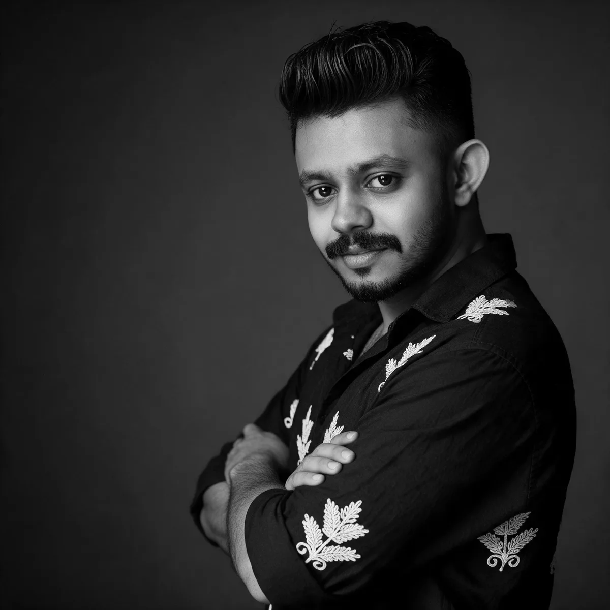 Vishnu, founder of Mayaroopan AI Studio, in a black-and-white studio portrait with arms crossed
